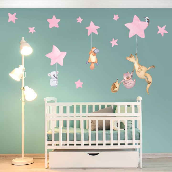 Nursery wall decals of Australian animals hanging from stars above crib