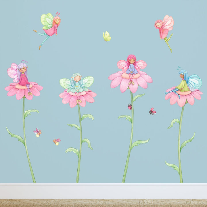 Four fairies sit on beautiful pink flowers with nature all around them in this wall decal set made by little tall tales studio