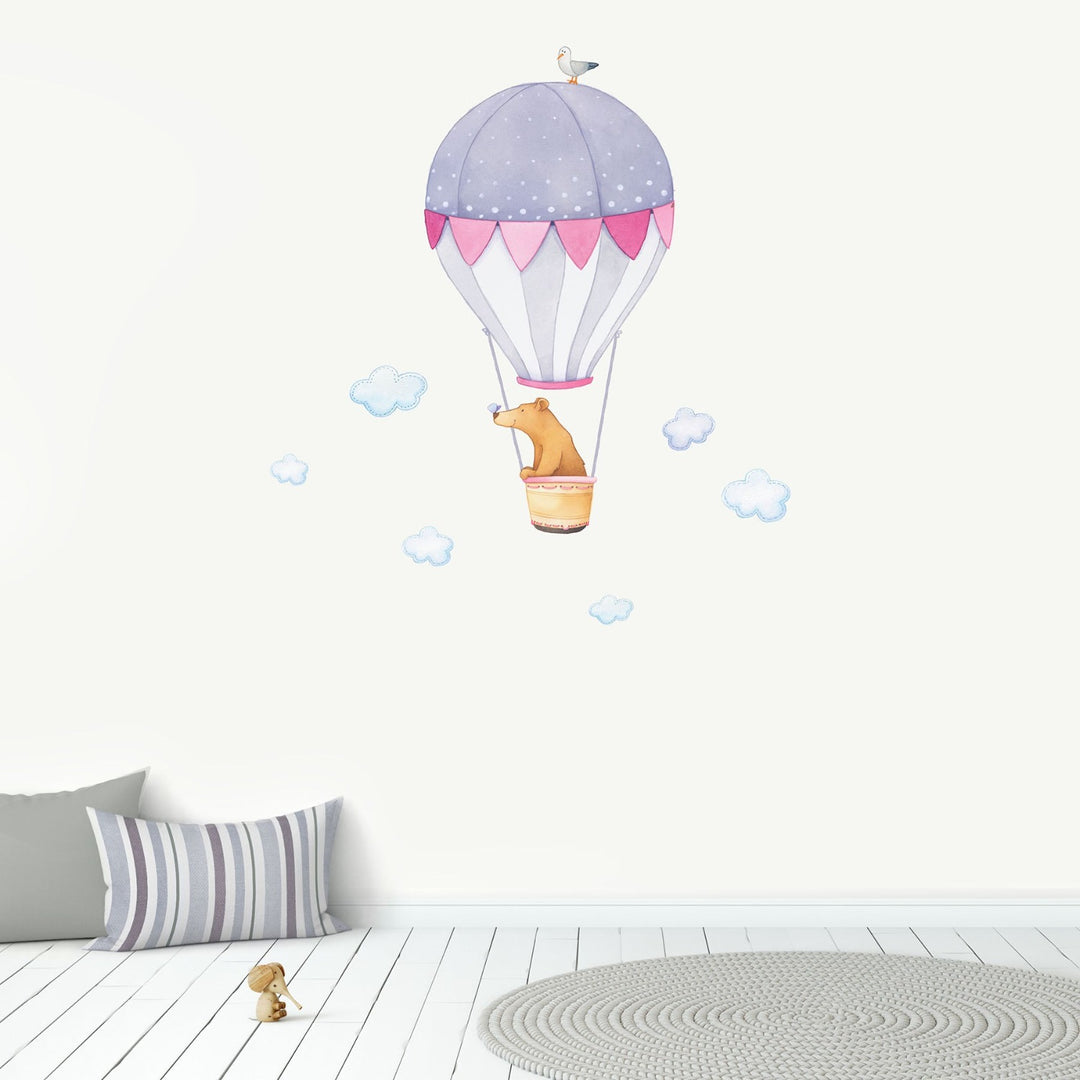 A bear in a hot air balloon repositionable wall sticker with blue clouds