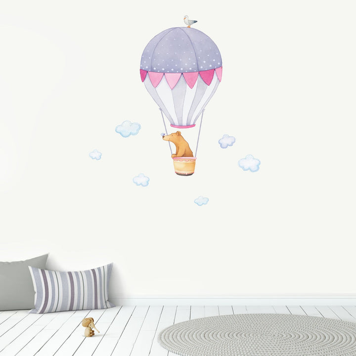A bear in a hot air balloon repositionable wall sticker with blue clouds