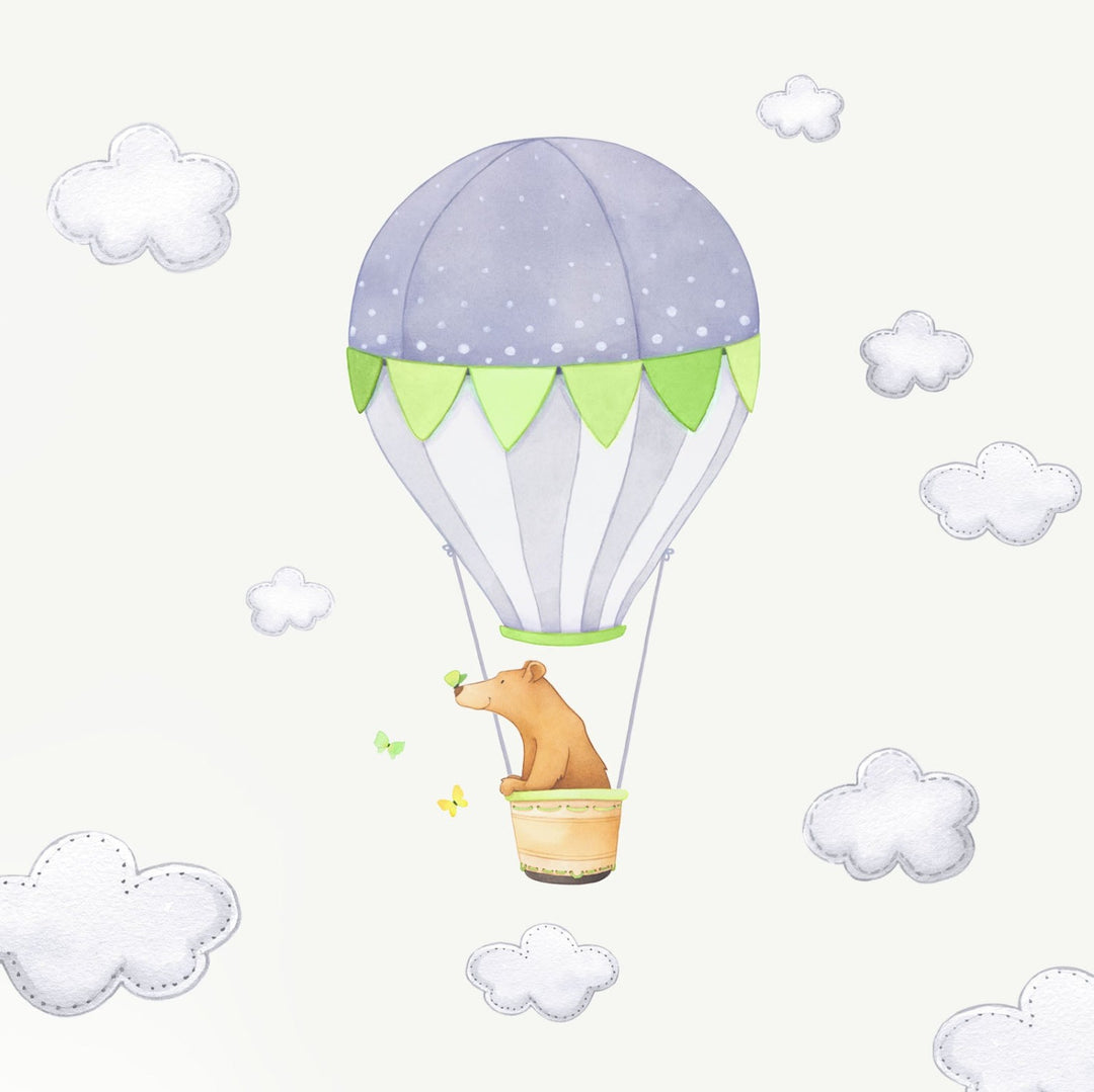 A bear in a green hot air balloon fabric wall decal with grey clouds