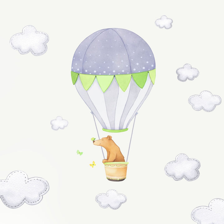 A bear in a green hot air balloon fabric wall decal with grey clouds